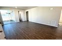 Spacious living room area with sliding glass doors and wood-look flooring at 2263 Serenidad St, Brighton, CO 80601