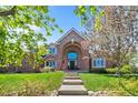Charming brick home featuring an arched doorway, manicured lawn, and stone walkway leading to the entrance at 3 White Pelican Cir, Thornton, CO 80241
