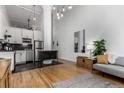 Open-concept living room featuring modern furnishings, hardwood floors, and a kitchen area at 720 16Th St # 311, Denver, CO 80202