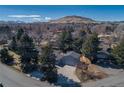 Aerial view of the property showcasing the large lot, mature trees, and mountain views at 2605 Crabapple Ct, Golden, CO 80401