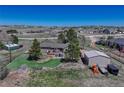 The home features a lush, green backyard with mature trees, a small deck, and an outbuilding at 7605 Shenandoah Dr, Elizabeth, CO 80107