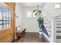 Inviting entryway with wooden door, bench, and a staircase with decorative blue accent at 142 N Logan St, Denver, CO 80203