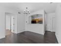 Dining area with dark hardwood floors, modern light fixture, and adjacent open kitchen at 5255 Memphis St # 1112, Denver, CO 80239