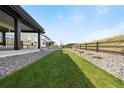 Well-maintained backyard with green grass, rock ground cover, and wooden fencing for privacy and charm at 455 Rogers Way, Castle Rock, CO 80104