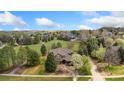 Sprawling estate showcasing lush landscaping, mature trees, a circular driveway, and neighboring homes at 7220 Spring Creek Cir, Niwot, CO 80503