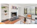 Comfortable living room with fireplace and built-in shelves, illuminated by a large window at 2297 S Oswego Way, Aurora, CO 80014