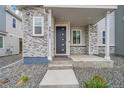 A close-up of the entryway with stacked stone accents surrounding the front door at 4612 S Wenatchee St # A, Aurora, CO 80015