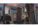 Dusk view of a townhome exterior featuring a red brick chimney and welcoming curb appeal at 8300 W 87Th Dr # B, Arvada, CO 80005
