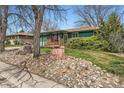Ranch home featuring a well-kept lawn, rock garden, mature landscaping, and covered porch at 13621 E Center Ave, Aurora, CO 80012
