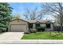 Charming single-story home with well-maintained lawn, stone accents, and attached two-car garage at 13806 W 66Th Dr, Arvada, CO 80004