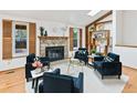 Cozy living room with stone fireplace, wood shutters, and comfortable seating arrangement on hardwood floors at 13806 W 66Th Dr, Arvada, CO 80004