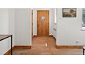 Traditional entryway featuring hardwood floors, white walls and a wooden front door at 2535 Leyden St, Denver, CO 80207