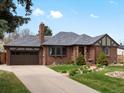 Charming brick home featuring an attached garage and a well-manicured front yard at 2535 Leyden St, Denver, CO 80207