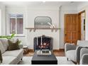 Cozy living room with a traditional fireplace, a decorative mirror, and comfortable seating creating a welcoming atmosphere at 2535 Leyden St, Denver, CO 80207