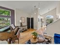 Bright entryway with hardwood floors, modern light fixtures, a piano, and views of the backyard at 9016 W Alabama Pl, Lakewood, CO 80232