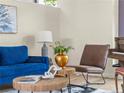 Cozy living area showcasing a blue sofa, round wood table, a leather chair, and hardwood flooring at 9016 W Alabama Pl, Lakewood, CO 80232