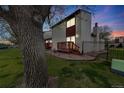 Exterior view of home with a nice yard, deck and sunset at 1236 Sequerra St, Broomfield, CO 80020