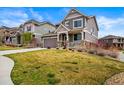 Attractive home with an attached garage, inviting front porch, and lush green lawn at 16857 W 87Th Ave, Arvada, CO 80007