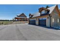 Detached two-car garage next to a main house features an upper story loft and ample parking at 8191 S Homesteader Dr, Morrison, CO 80465