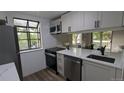 Bright kitchen features white cabinetry, stainless appliances, and a window overlooking the outdoors at 12506 E Cornell Ave # 201, Aurora, CO 80014