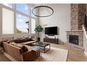 Vaulted living room with a stunning stone fireplace, large windows, and a comfortable seating arrangement at 9591 Sunset Hill Dr, Lone Tree, CO 80124