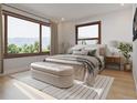 Bedroom with large windows offering natural light, mountain views, and warm textures, a seating bench, and neutral colors at 526 N Fuller Placer Rd, Breckenridge, CO 80424