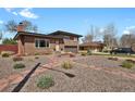 Brick home with a manicured yard, complemented by a stone walkway and a two-car garage at 3901 Newland St, Wheat Ridge, CO 80033