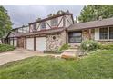 Close-up of a brick home with a two-car garage and a well-manicured lawn at 2556 S Eagle Cir, Aurora, CO 80014