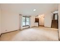 Spacious living room boasts natural light, plush carpeting, and an open staircase at 2556 S Eagle Cir, Aurora, CO 80014