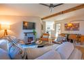 Comfortable living room with a ceiling fan, stone fireplace, and an open floor plan at 5541 Umatilla St, Denver, CO 80221