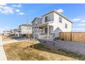 View of a charming two-story home with a covered front porch and landscaped yard at 4743 Hatcher Dr, Brighton, CO 80601