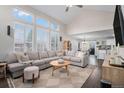 Spacious living room with soaring ceilings, large windows, and comfortable seating, open to the kitchen at 13340 Saint Paul St, Thornton, CO 80241
