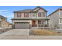 Two-story home featuring neutral siding, red shutters, covered porch, and attached two car garage at 3438 Cade Ct, Castle Rock, CO 80104
