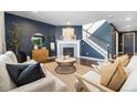 Cozy living room featuring a fireplace, neutral furniture, stylish decor, and dark accent wall at 3438 Cade Ct, Castle Rock, CO 80104