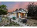 Charming home with stone accents, inviting front porch, and a well-maintained yard as the sun sets at 205 Beech St, Hudson, CO 80642
