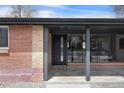 Inviting front entrance with brick accents, large windows, and a stylish black front door at 6839 E 21St Ave, Denver, CO 80207