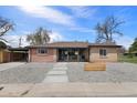 Charming single-story home with a brick facade, modern front door, and landscaped front yard at 6839 E 21St Ave, Denver, CO 80207