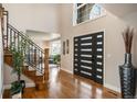 Grand foyer with soaring ceilings, hardwood floors, modern front door, and elegant staircase at 15946 W Ellsworth Ln, Golden, CO 80401