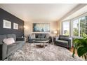 Cozy living room featuring a plush rug, comfortable seating, and bright natural light from the bay window at 15946 W Ellsworth Ln, Golden, CO 80401