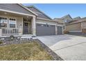 Welcoming front entrance featuring stone accents, a covered porch, and a three-car garage at 1832 Marlowe Cir, Erie, CO 80516
