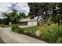 Two story home with brick and tan siding, showcasing the landscaped yard and two car garage at 10373 W 75Th Ave, Arvada, CO 80005