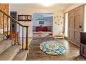 Inviting foyer features wood floors, a staircase, and an open view into the adjacent living room at 10373 W 75Th Ave, Arvada, CO 80005