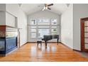 Spacious living room featuring hardwood floors, a fireplace, high ceilings, and a piano at 1513 Cannon Mountain Dr, Longmont, CO 80503