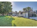 Expansive backyard featuring lush lawn, a basketball hoop, and a patio area perfect for entertaining at 3695 E Dartmouth Ave, Denver, CO 80210