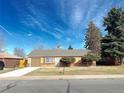 Charming single-story home with a well-maintained front yard, bushes and a one car garage at 1120 Tucson St, Aurora, CO 80011