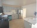 Updated kitchen featuring gray cabinets, stainless steel refrigerator, and marble counter tops at 1120 Tucson St, Aurora, CO 80011