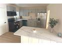 Updated kitchen featuring gray cabinets, stainless steel refrigerator, and marble counter tops at 1120 Tucson St, Aurora, CO 80011