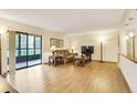 Bright living room with wood floors, comfortable seating, a flatscreen TV, and sliding door access to the outdoors at 13952 E Marina Dr # 102, Aurora, CO 80014