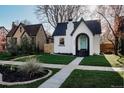 Charming home with a well-manicured lawn, arched entryway, and a neatly landscaped front yard at 2085 Krameria St, Denver, CO 80207
