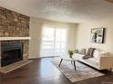 Comfortable living area featuring a stone fireplace, and sliding door to the exterior at 18105 E Ohio Ave # 102, Aurora, CO 80017